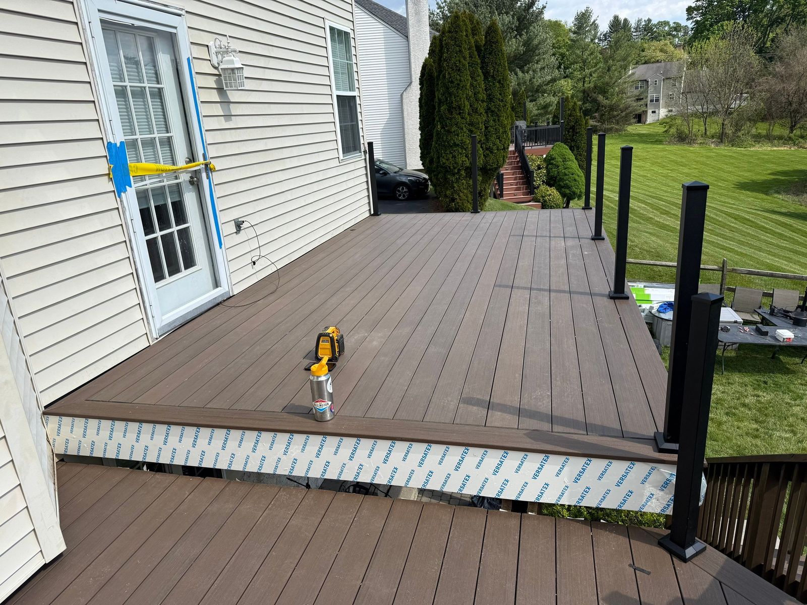 Brown composite deck under construction with black railing posts at a home in Delaware County, PA