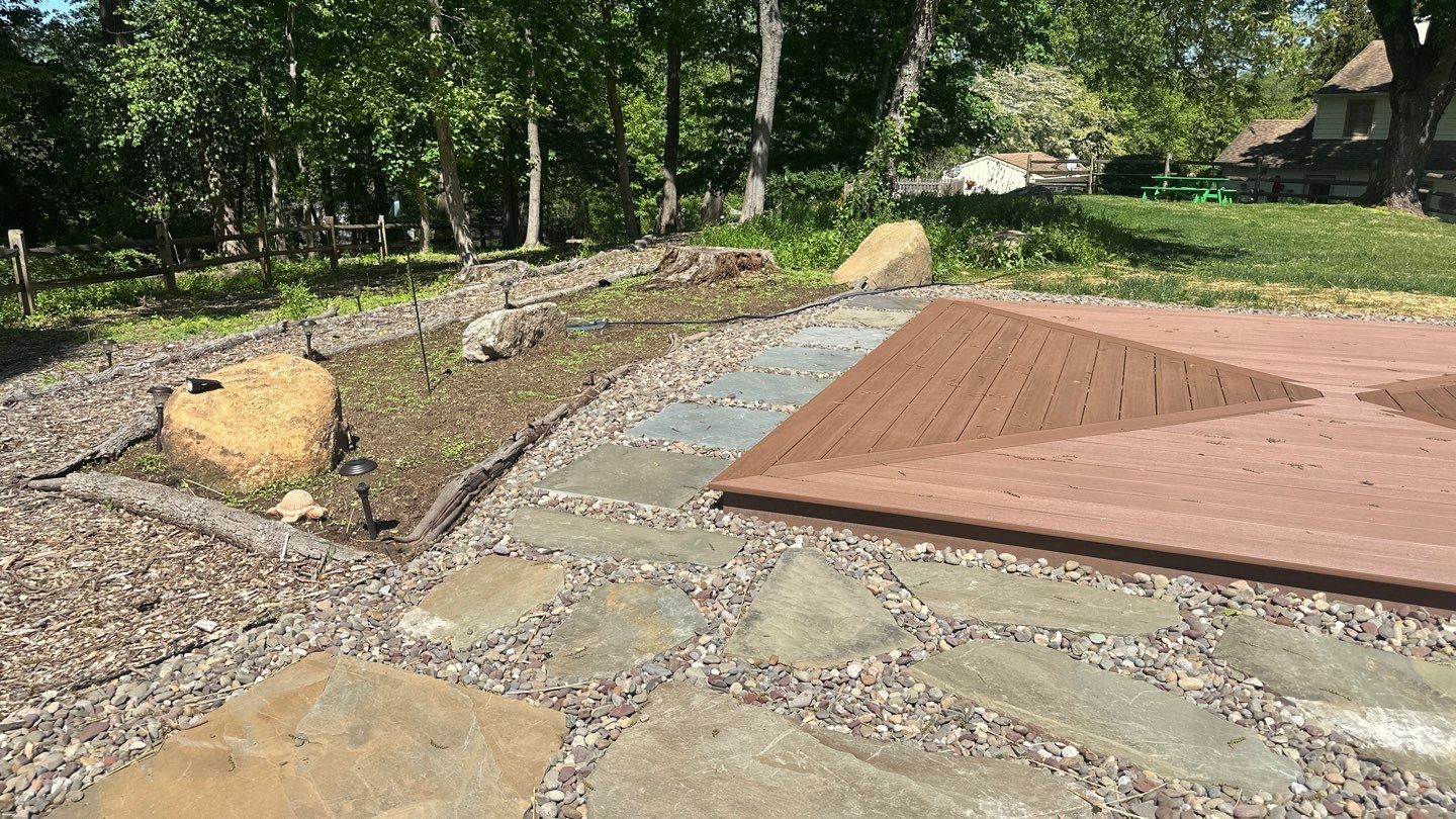 JHL construction crew installing brown composite deck boards on a raised deck at a home in Delaware County, PA