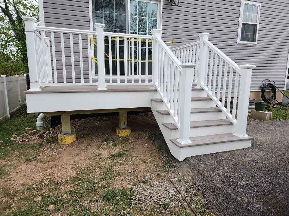 Raised gray composite deck with white vinyl railing and stairs at a home near Newtown Square, PA